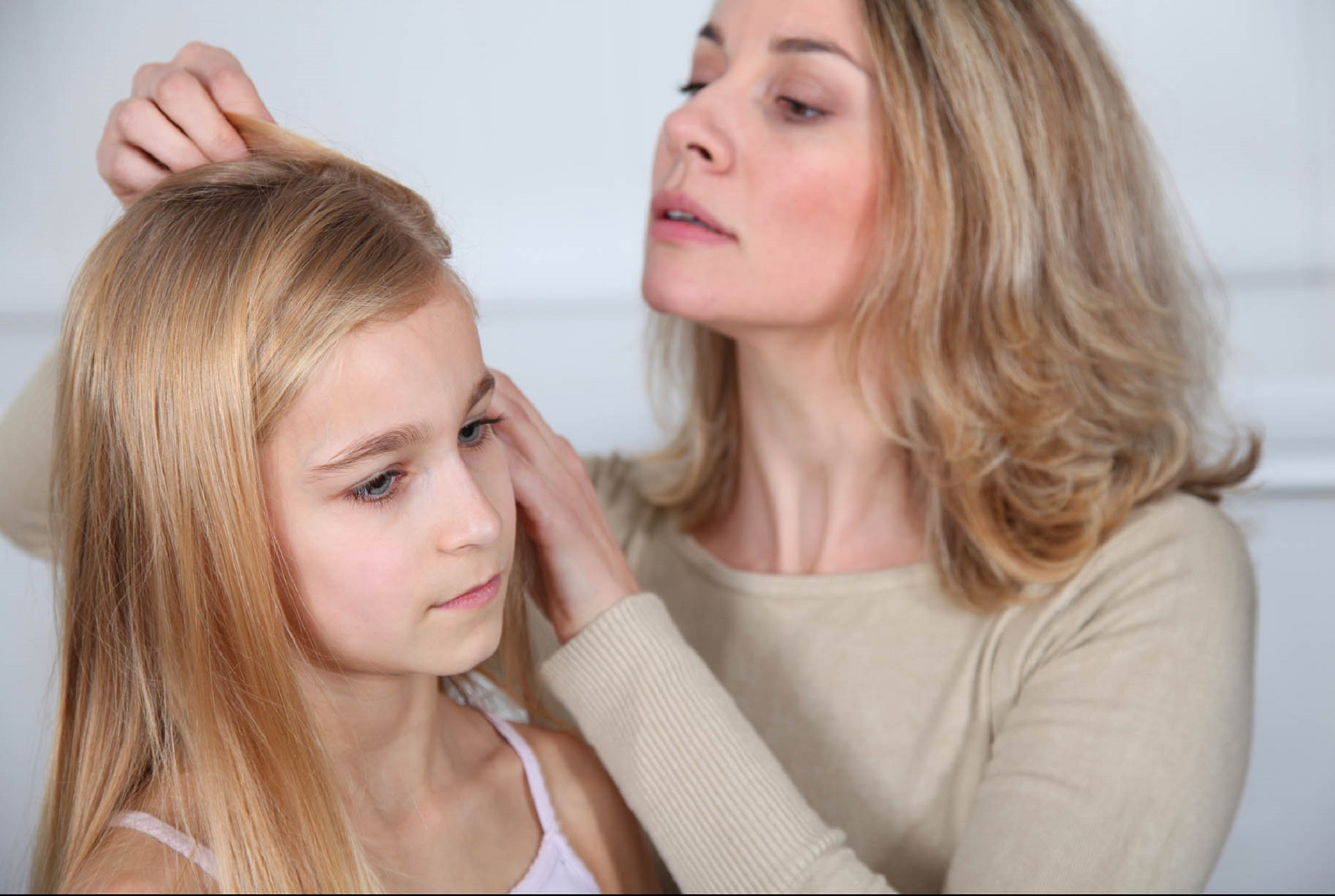 mamma controlla i capelli della figlia per vedere se ha i pidocchi