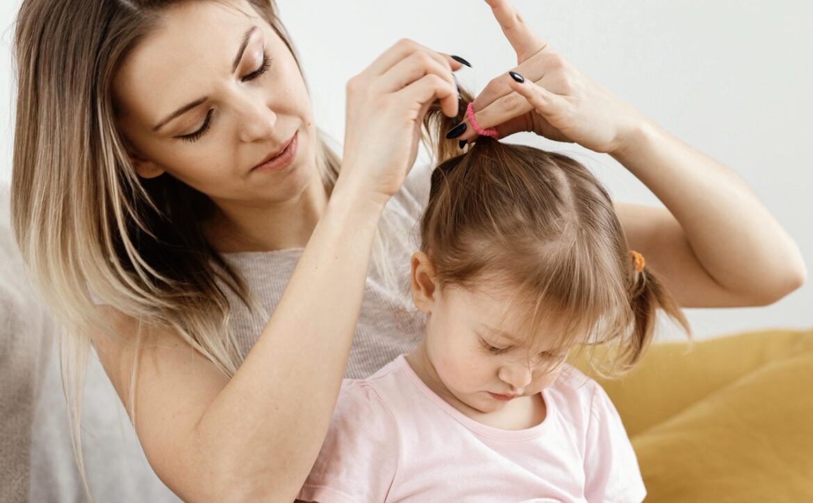 Mamma che controlla i capelli della figlia per prevenire i pidocchi